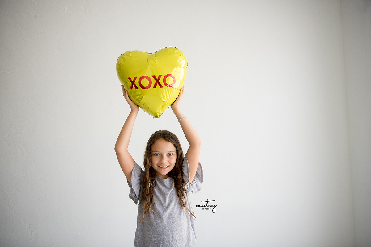 valentines day little girl holding heart shaped balloon miami family photographer
